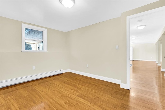 empty room with hardwood / wood-style flooring and baseboard heating