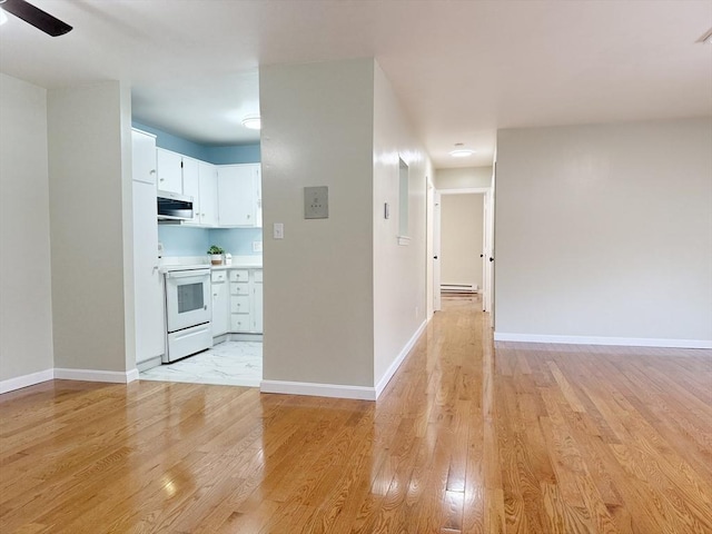 kitchen featuring white cabinets, electric range, light hardwood / wood-style floors, and baseboard heating