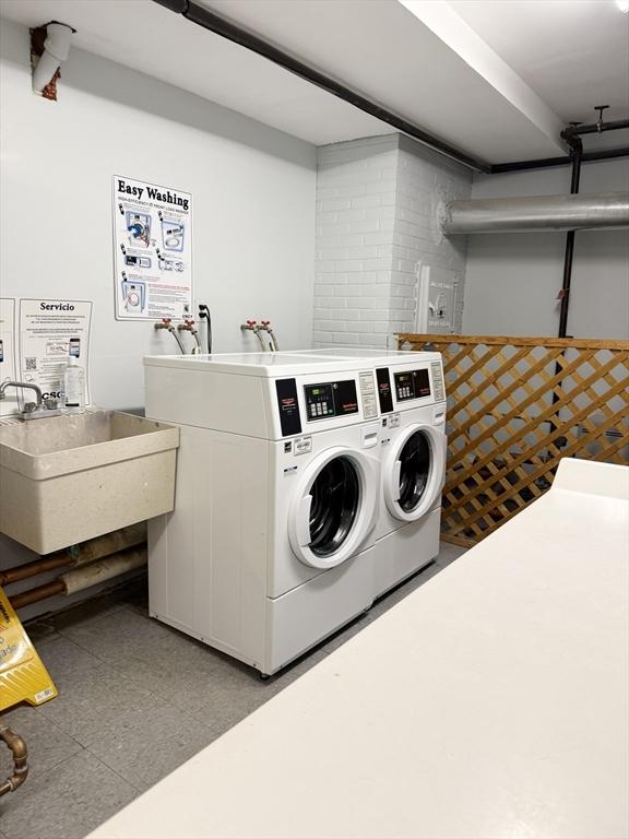 clothes washing area with washer and clothes dryer and sink