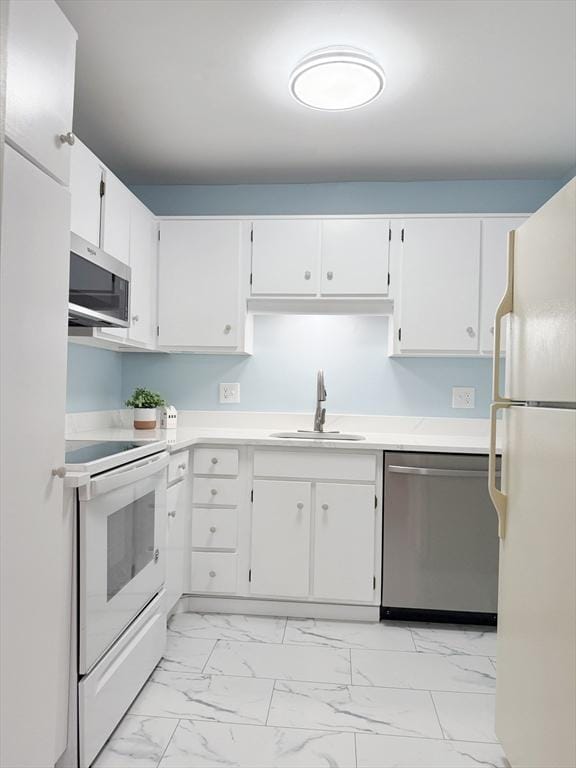 kitchen featuring stainless steel appliances, white cabinetry, and sink