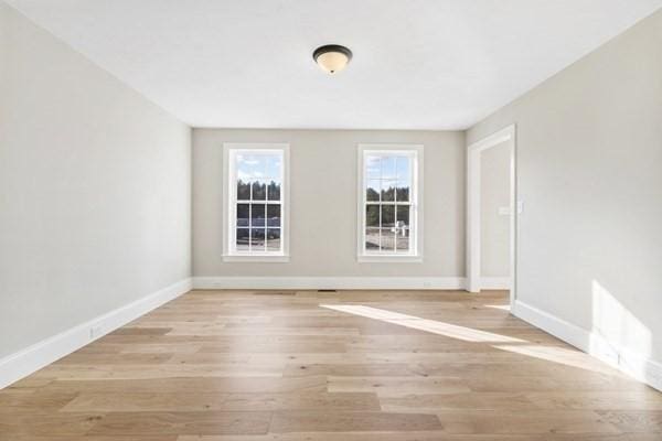 empty room with light wood-style flooring and baseboards