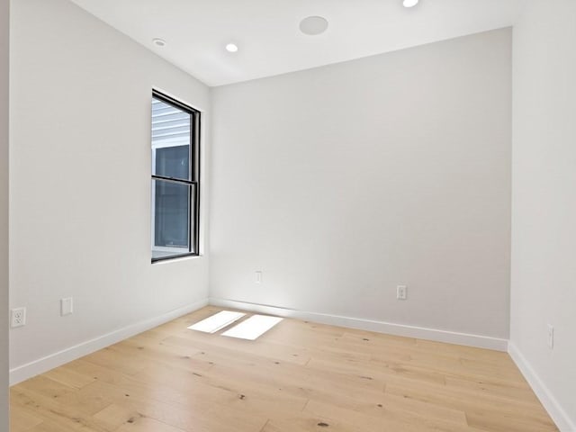 spare room with light wood-style floors, baseboards, and recessed lighting