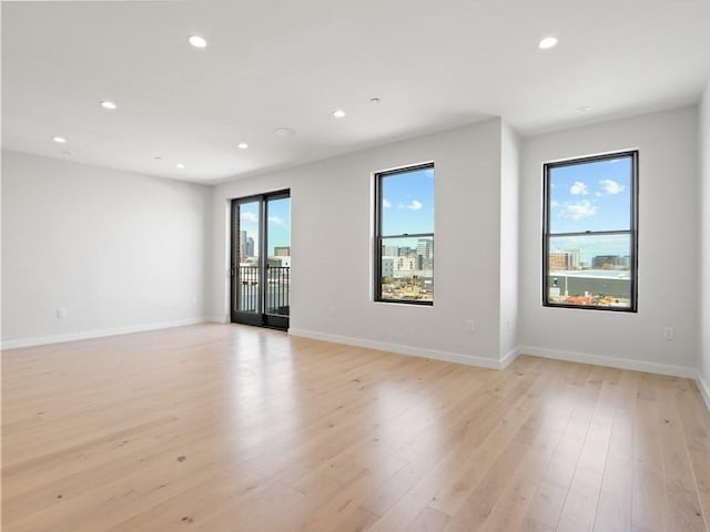spare room with recessed lighting, light wood-style floors, and baseboards