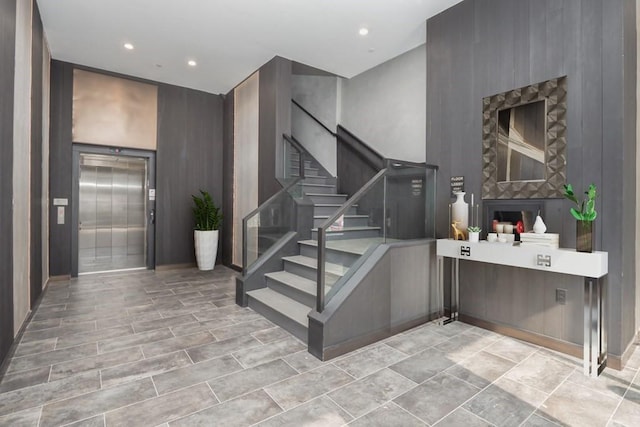 staircase featuring elevator and recessed lighting