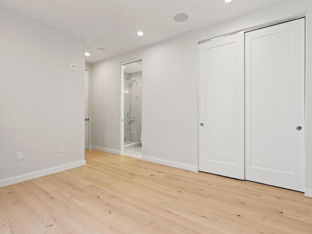 unfurnished bedroom with recessed lighting, baseboards, a closet, light wood-type flooring, and connected bathroom