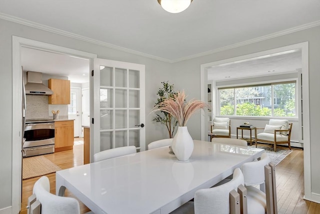 dining area featuring light wood-type flooring and ornamental molding