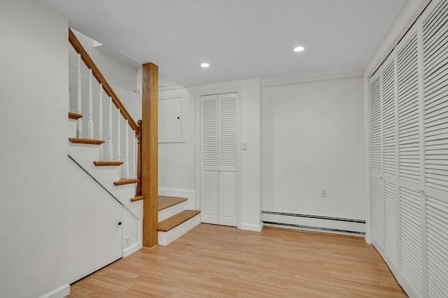 interior space with baseboard heating, light wood-style flooring, recessed lighting, baseboards, and stairway