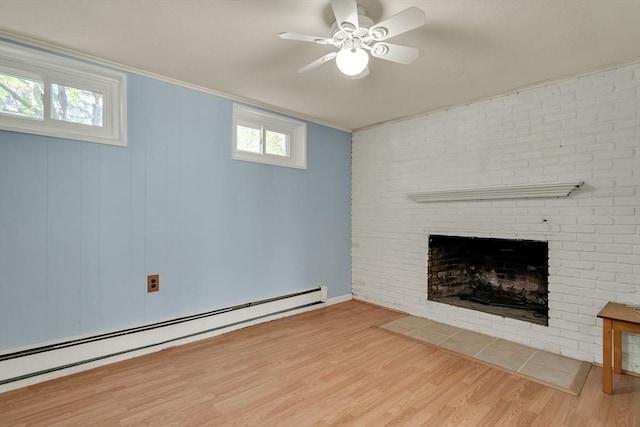 unfurnished living room featuring crown molding, a brick fireplace, a ceiling fan, wood finished floors, and a baseboard heating unit