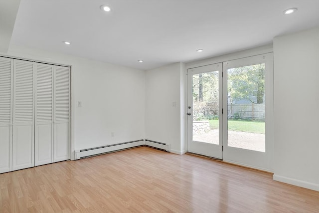 interior space featuring access to outside, a baseboard radiator, light wood-style flooring, and recessed lighting