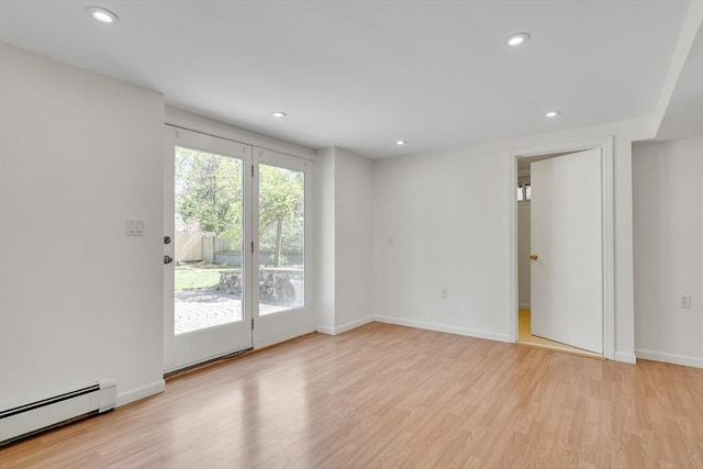 empty room with wood finished floors, recessed lighting, baseboards, and a baseboard heating unit