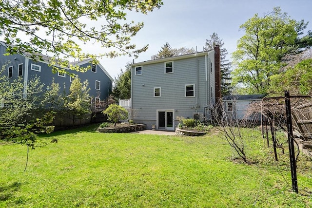 back of house with a yard, fence, a chimney, and a patio area