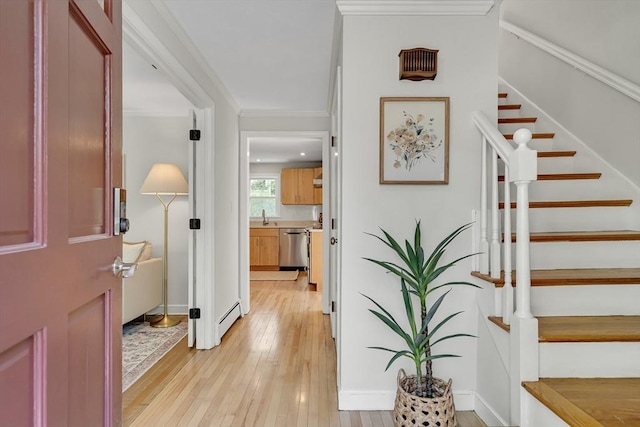 entrance foyer with baseboards, a baseboard radiator, light wood-style flooring, and stairway