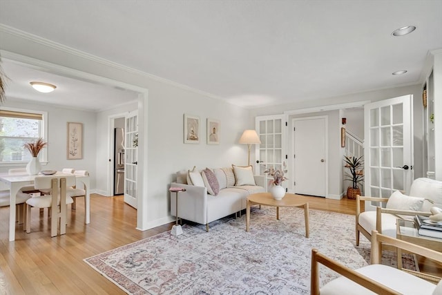 living room featuring crown molding, stairs, baseboards, light wood-style floors, and recessed lighting