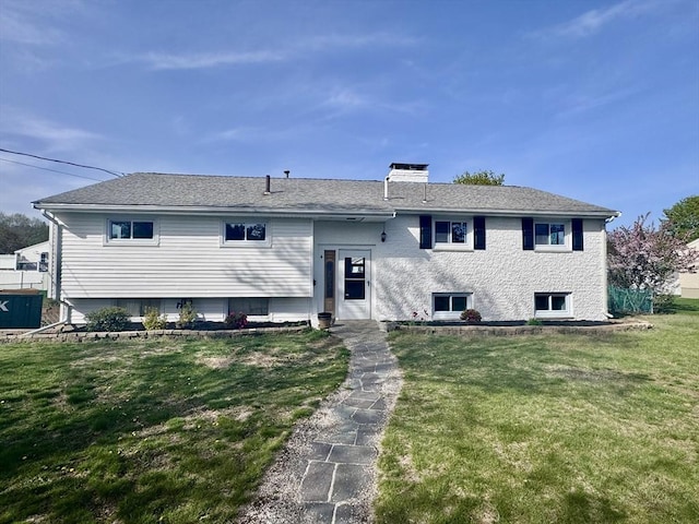 raised ranch featuring a front lawn and a chimney