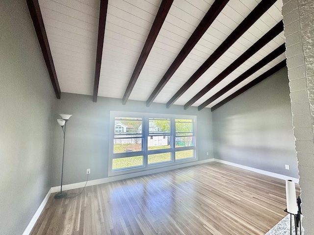 unfurnished living room featuring baseboards, wood ceiling, wood finished floors, and vaulted ceiling with beams