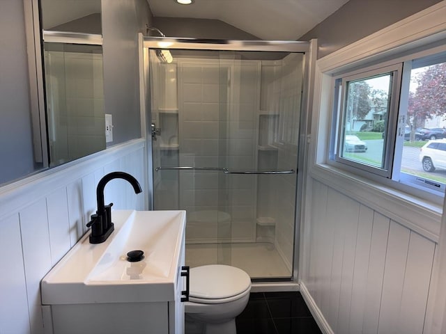 full bathroom with toilet, a shower stall, and a decorative wall