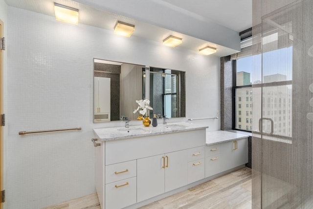453 Washington St Unit 11E, Boston, MA 02111 - bathroom with double vanity, a shower stall, and wood finished floors