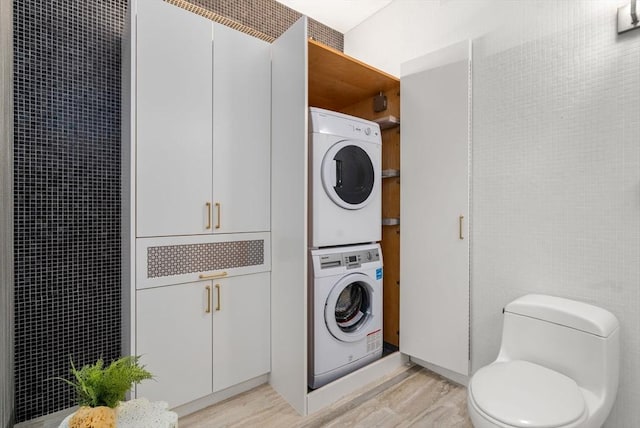 453 Washington St Unit 11E, Boston, MA 02111 - washroom featuring a heating unit, stacked washer and clothes dryer, and light wood finished floors