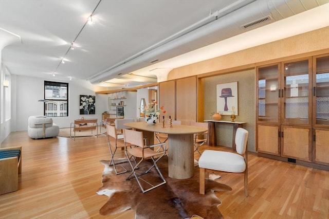 453 Washington St Unit 11E, Boston, MA 02111 - dining space featuring light wood-type flooring and rail lighting