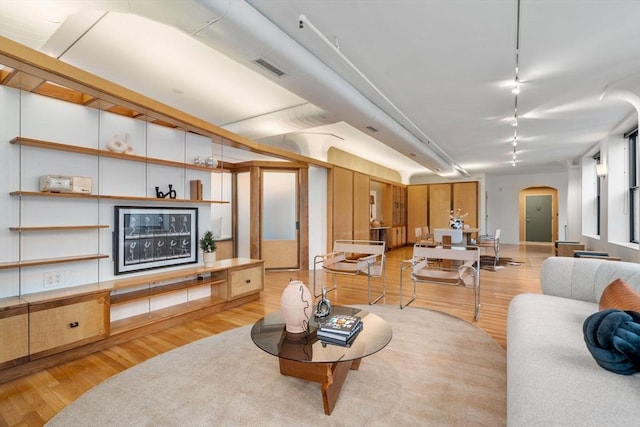 453 Washington St Unit 11E, Boston, MA 02111 - living area featuring light wood finished floors, arched walkways, and track lighting
