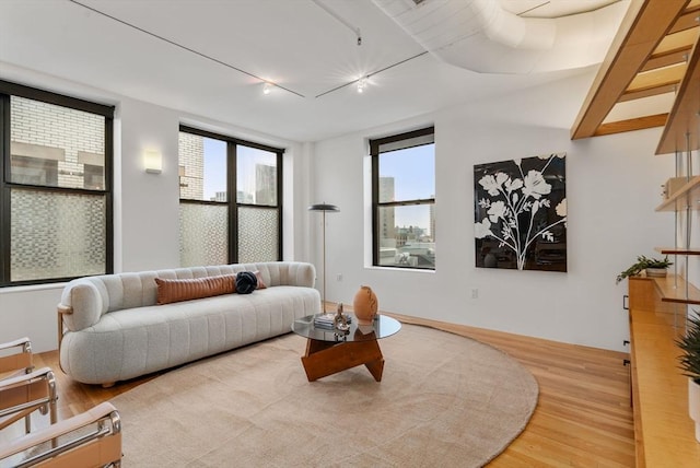 453 Washington St Unit 11E, Boston, MA 02111 - living room featuring wood finished floors, rail lighting, and healthy amount of natural light