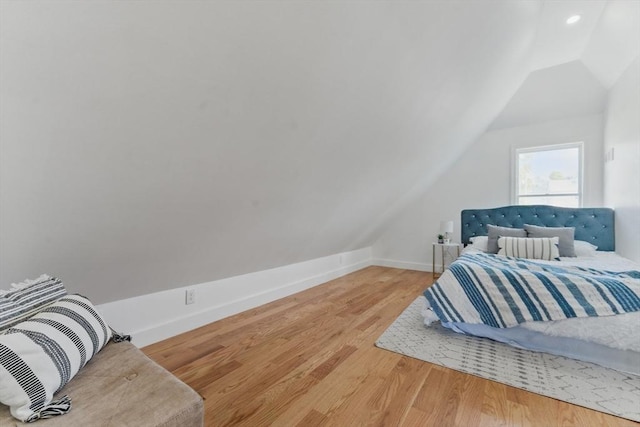 bedroom with lofted ceiling, wood finished floors, recessed lighting, and baseboards