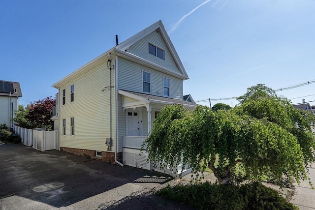american foursquare style home featuring fence and a porch