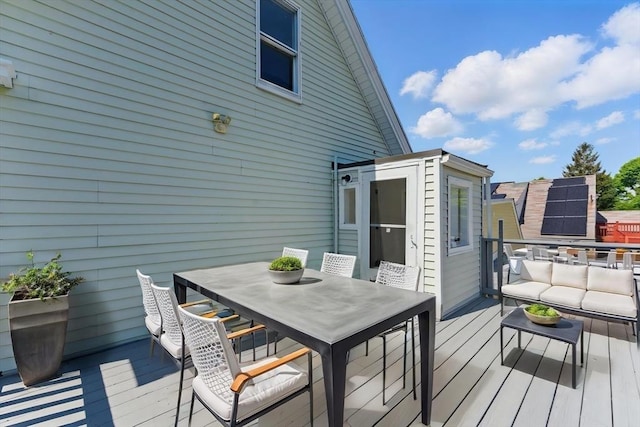 wooden terrace featuring outdoor dining area and an outdoor hangout area