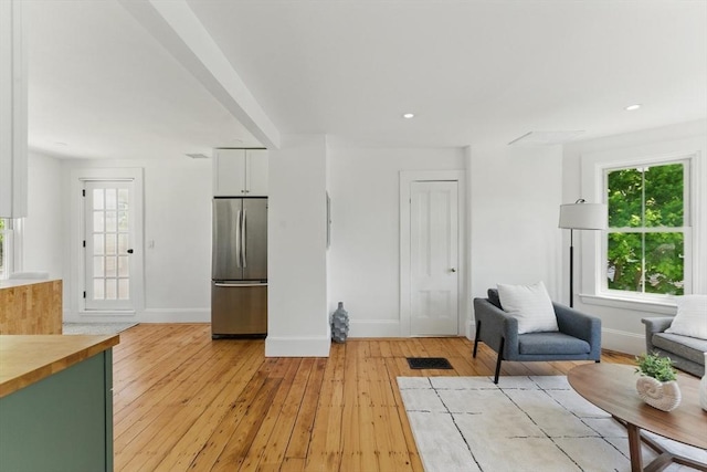 living area featuring baseboards, light wood-type flooring, and recessed lighting