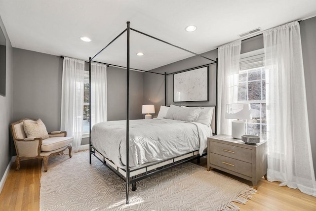 bedroom featuring light wood finished floors, baseboards, visible vents, and recessed lighting