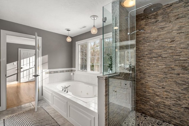 bathroom with a whirlpool tub, visible vents, tiled shower, and tile patterned floors