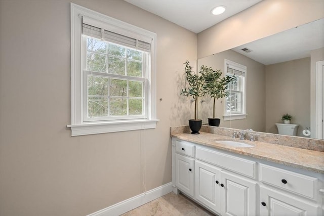 bathroom with visible vents, vanity, toilet, and baseboards