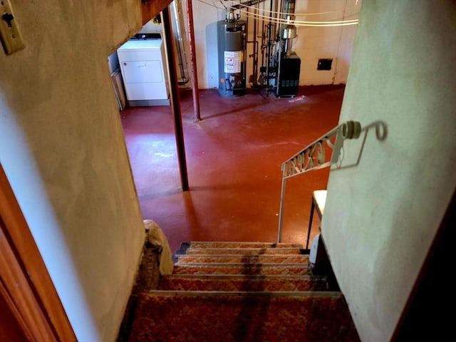 stairs featuring water heater, washer / clothes dryer, concrete flooring, and a heating unit