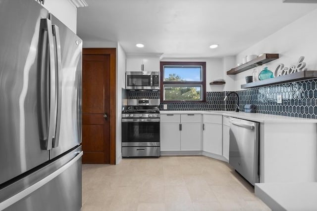 kitchen featuring a sink, white cabinets, light countertops, appliances with stainless steel finishes, and decorative backsplash