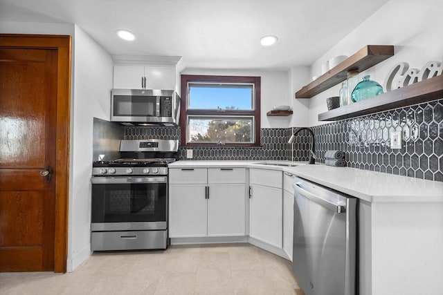 kitchen featuring a sink, stainless steel appliances, light countertops, white cabinetry, and backsplash