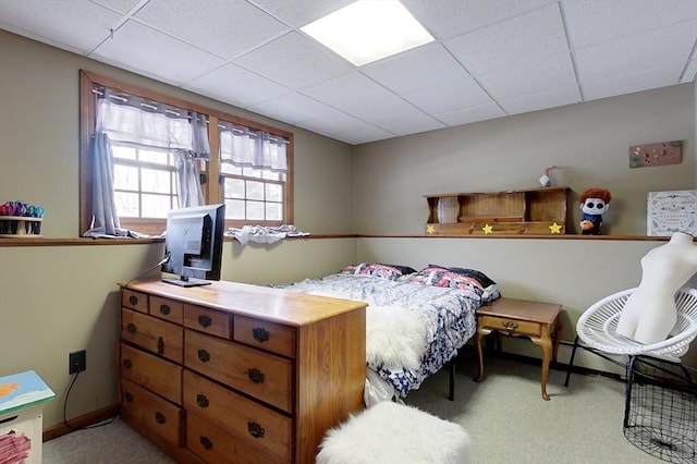 carpeted bedroom featuring baseboards and a paneled ceiling