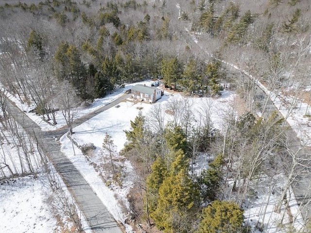 snowy aerial view featuring a forest view