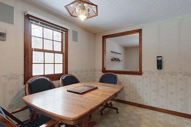 office with a notable chandelier, a textured ceiling, wallpapered walls, baseboards, and light floors