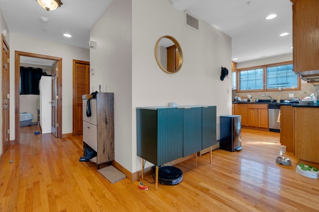 hallway with sink and light wood-type flooring