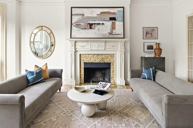 living room featuring a tiled fireplace, crown molding, and hardwood / wood-style floors