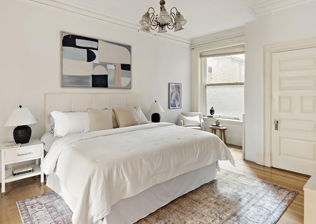 bedroom featuring wood-type flooring, crown molding, and an inviting chandelier