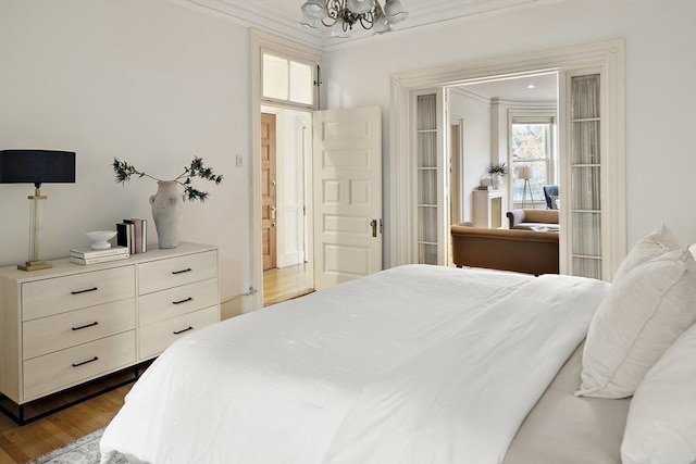 bedroom with dark hardwood / wood-style flooring, crown molding, and a notable chandelier