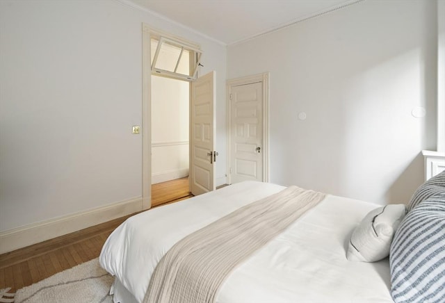 bedroom with ornamental molding and hardwood / wood-style flooring