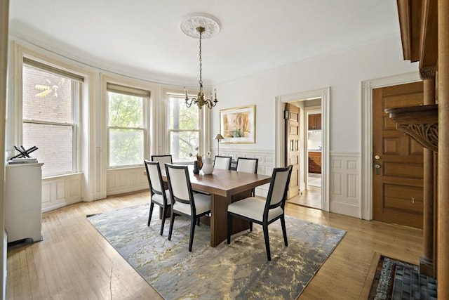 dining area with a chandelier and light hardwood / wood-style flooring