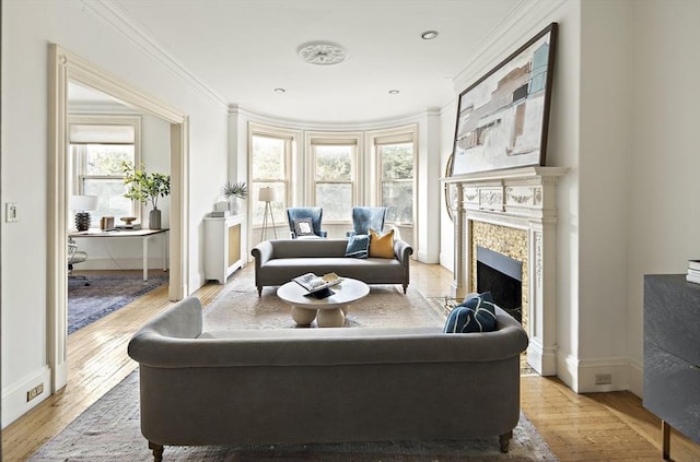 sitting room with a fireplace, light wood-type flooring, and ornamental molding