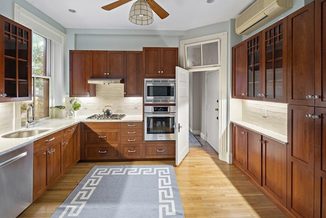 kitchen featuring a wall mounted air conditioner, sink, appliances with stainless steel finishes, and tasteful backsplash