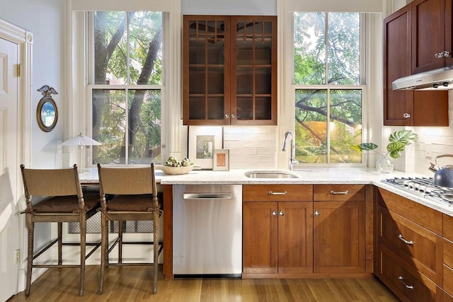 kitchen featuring light stone counters, stainless steel appliances, sink, and tasteful backsplash