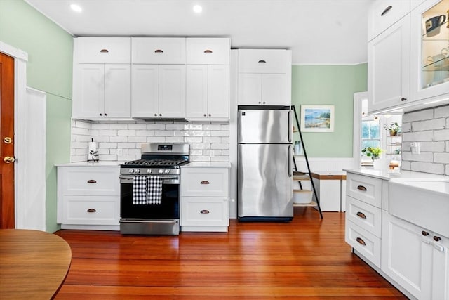 kitchen featuring glass insert cabinets, white cabinetry, appliances with stainless steel finishes, and light countertops