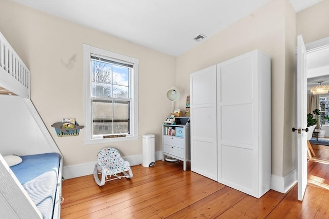 bedroom featuring visible vents, baseboards, and wood finished floors