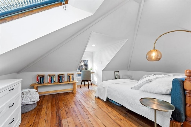 bedroom with vaulted ceiling and light wood-style floors